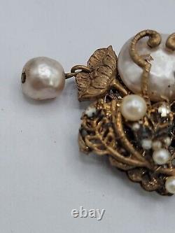 Broche de perle baroque Miriam Haskell avec motif floral en filigrane en métal ton or signée.