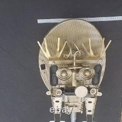 Tête de robot unique en métal recyclé avec des pièces de satellite peintes en or et une grande vis.